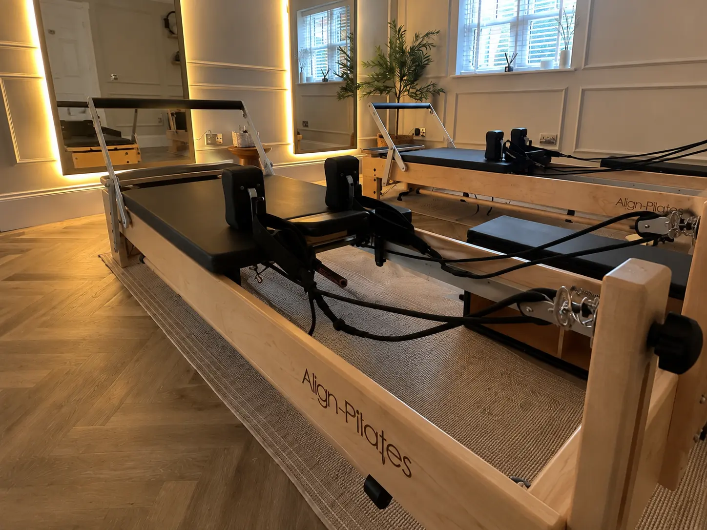 Close view of two premium wooden Align-Pilates reformers in the Rewind Pilates studio in Poole